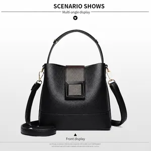 Front view of black pebble leather bucket bag with brown flap and gold metal buckle