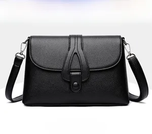 Vue détaillée d'un sac bandoulière noir avec texture grainée et fermeture à rabat
