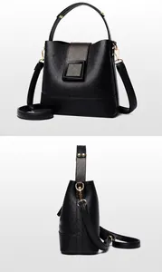 Detail view showing black lychee leather bucket bag with golden hardware and strap