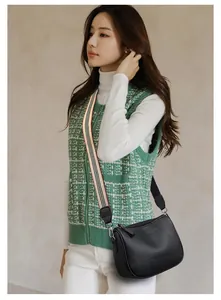 Fashionable black pebbled leather crescent saddle bag with striped fabric shoulder strap