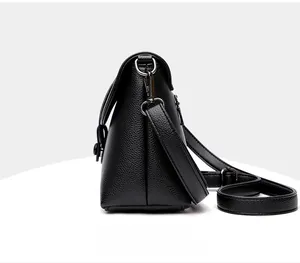 Vue latérale d'un sac à bandoulière en cuir grainé noir avec des détails argentés fins