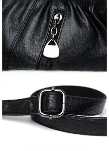 Detail of silver zipper closure and adjustable shoulder strap on black pebble leather bag
