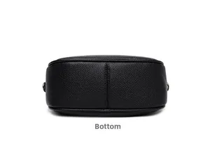 Detail view of the semi-circular bottom on black lychee grain faux leather saddle bag