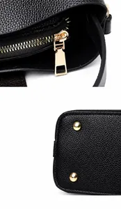 Detail of gold metal zipper and protective bottom rivets on black lychee leather bag