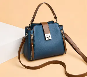 Detail der marineblauen Beuteltasche aus Leder mit Silber-Schnalle und braunem Gurt