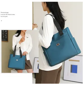 Detail of teal nylon tote bag featuring side water bottle pocket and silver logo plaque