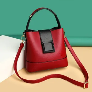 Chic red lychee grain leather bucket bag with black handles and gold hardware
