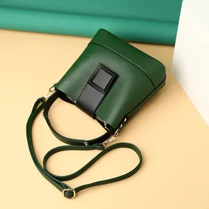 Dark green bucket bag with lychee texture, square buckle, and adjustable shoulder strap