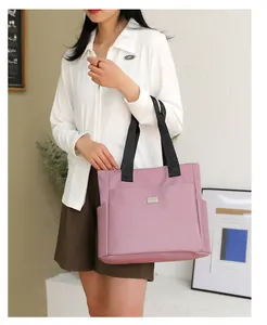 Pink large capacity tote bag with black strap showing side pocket and front zipper detail