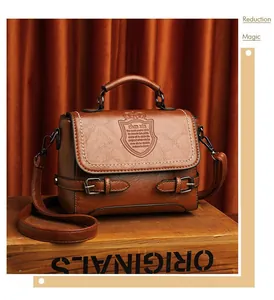 Détail du sac à main vintage marron avec logo couronne embossé et poignée supérieure