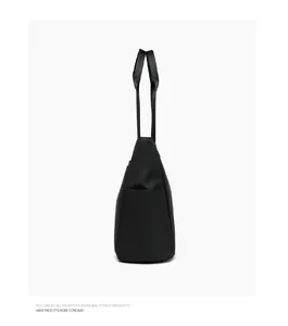 Side view of black large capacity nylon tote bag with functional side pocket and long straps