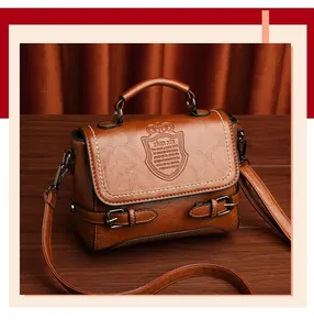 Détail du sac marron caramel à texture craquelée avec logo écusson et boucles métal