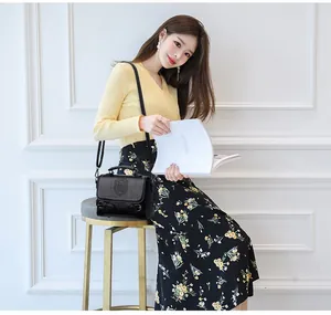 Détail d'un sac messager vintage en cuir PU noir avec logo gaufré et boucle décorative