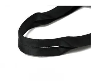 Close-up of thick woven black handles on a large capacity tote bag with durable stitching