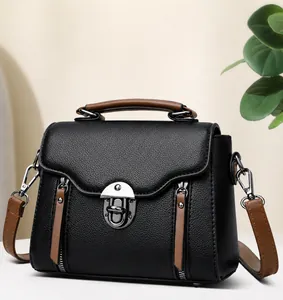 Vooraanzicht van vintage zwart leren crossbodytas met bruine handvatten en zilveren sluiting
