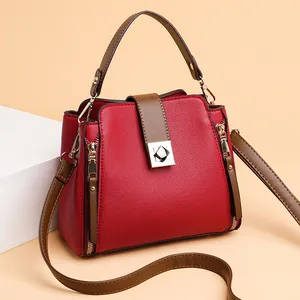 Rote und braune Leder-Beuteltasche mit goldenen Details in frontaler Perspektive