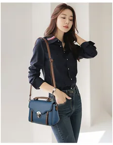 Close-up of retro crossbody bag with blue lychee texture and brown leather trim