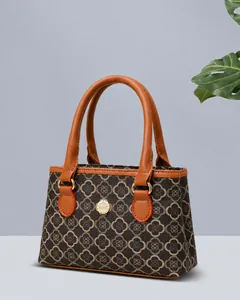Detailansicht der braunen Monogramm-Handtasche mit Ledergriffen und goldener Hardware