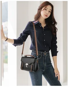 Close-up of retro black lychee leather crossbody bag with brown straps and metal turn-lock