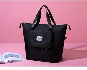 Detalle de bolsa de viaje negra en nailon impermeable con bolsillo y parche de moda