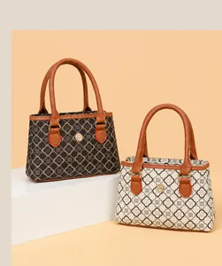 Detailansicht der Handtaschen mit Kleemuster und hochwertigen braunen Ledergriffen