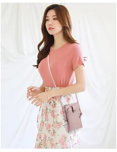 Détail de la texture litchi et du fermoir magnétique argenté sur un mini sac rose pour mobile