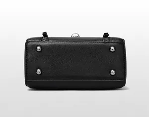 Detail van de onderkant van de crossbodytas in kiezelleder met zilveren metalen beschermnoppen
