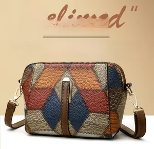Detailansicht der geometrischen Leder-Patchwork-Struktur mit goldenen Metallelementen