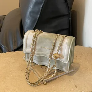 Elegant green marble pattern crossbody bag with golden chain and ball charm on stone