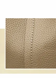 Close-up detail of premium pebbled leather texture and fine stitching on bucket bag