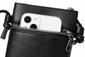 Détail de la pochette téléphone en cuir noir avec poche zippée pour cartes