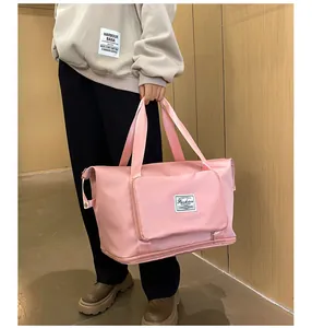 Detalle de bolsa de deporte rosa con tela resistente al agua y hebillas metálicas laterales