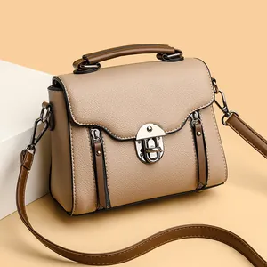 Elegant beige pebbled leather small square bag with brown handle and silver metal turn-lock