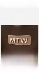 Detail of oxford fabric texture with MTW logo on brown anti-theft travel backpack