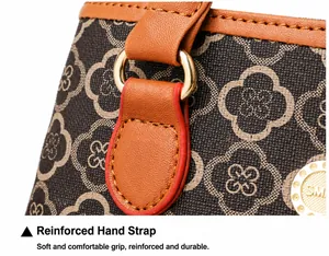 Detail der braunen Lederhandtasche mit Goldkleemuster und verstärkten Handgriffen