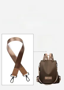Detail of a brown cowhide backpack featuring an adjustable wide woven shoulder strap