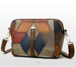 Detail einer Crossbody-Tasche mit geometrischem Farbmuster und goldener Reißverschluss