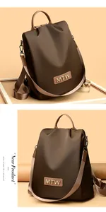 Close-up of brown Oxford cloth backpack showing the MTW logo and anti-theft zipper