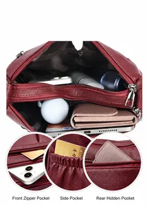 Dettaglio della borsa in pelle rosso vino con ampi scomparti con cerniera multistrato