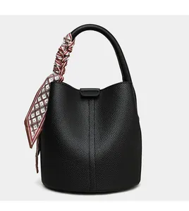 Detail of black pebbled leather bucket bag with geometric patterned silk scarf handle