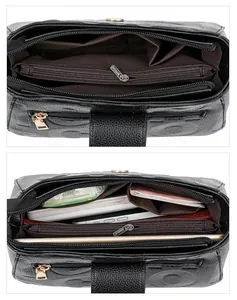 Detail view of the black leather crossbody bag interior showing multiple large compartments