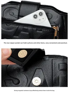 Detail of black litchi leather bag with a back zipper pocket and a magnetic buckle
