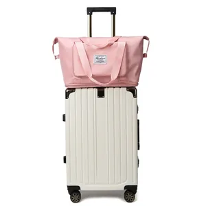 Bolso de viaje rosa de gran capacidad con banda para maleta sobre equipaje blanco