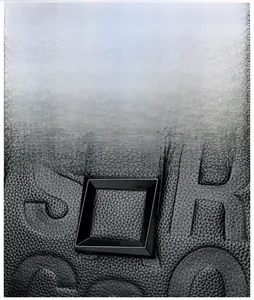 Detail of black litchi texture leather bag with embossed letters and glossy square buckle