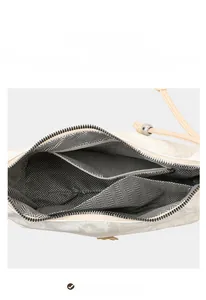 Detailed interior of the shoulder bag featuring zigzag lining, main compartment, and zipper pocket