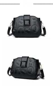 Macro shot of black litchi pattern leather texture with embossed letters on a crossbody bag