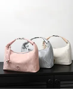 Detailed close-up of marble texture handbags with floral hardware in three soft colors