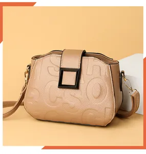 Detail of khaki pebbled leather bag with embossed letters and matte black square buckle