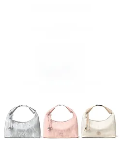 Detail of pleated dumpling bags in silver, pink, and beige with flower metal charms