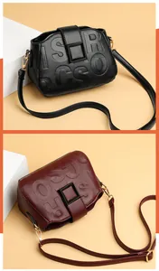 Close-up of litchi grain leather crossbody bags in black and wine red with buckle